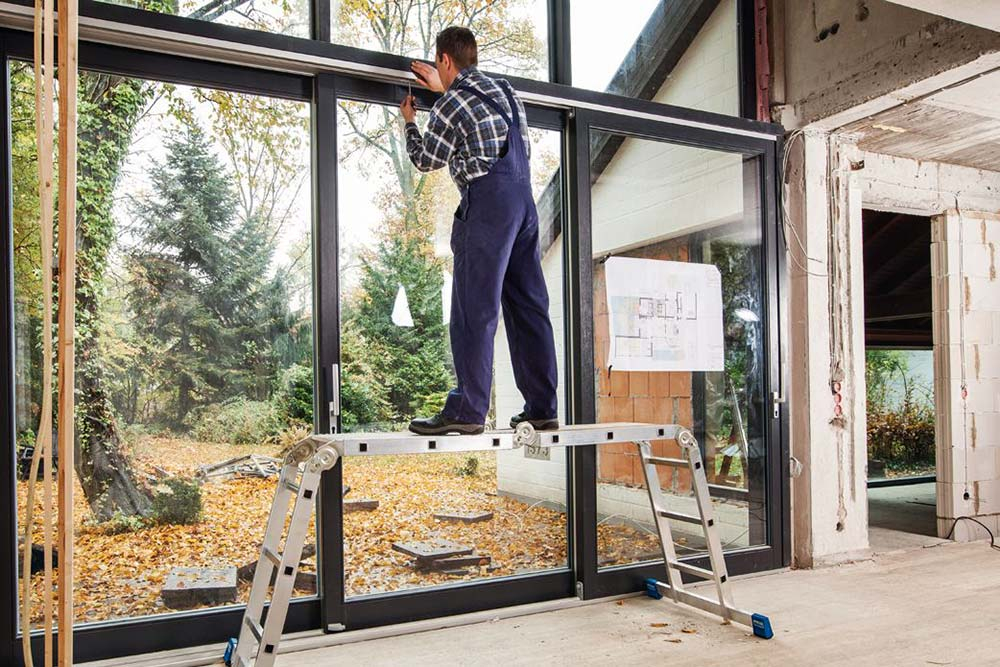 Mężczyzna wykonujący pracę na drabinie przegubowej